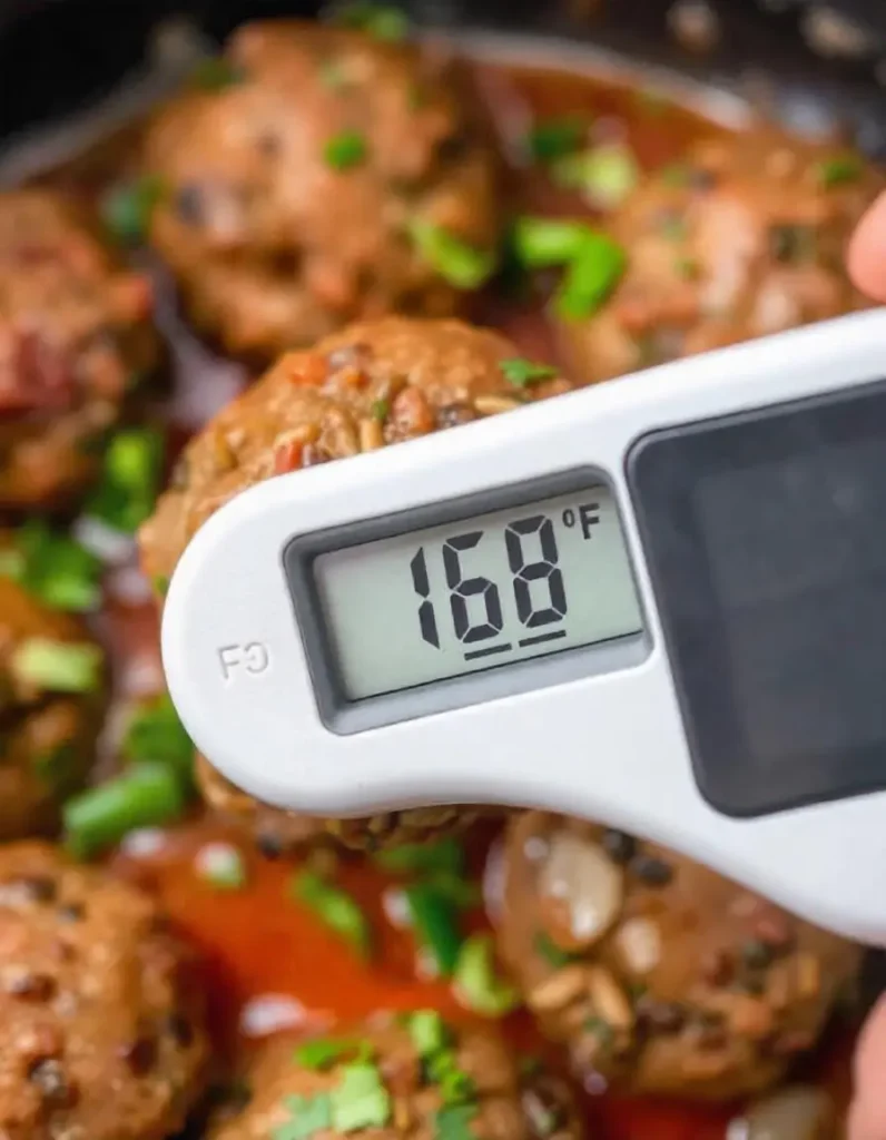 Moroccan Kefta Meatballs in Spiced Tomato Sauce: A Must-Try Dish 9 freepik a meat thermometer inserted into a moroccan kefta 21024 www.moroccaneats.com