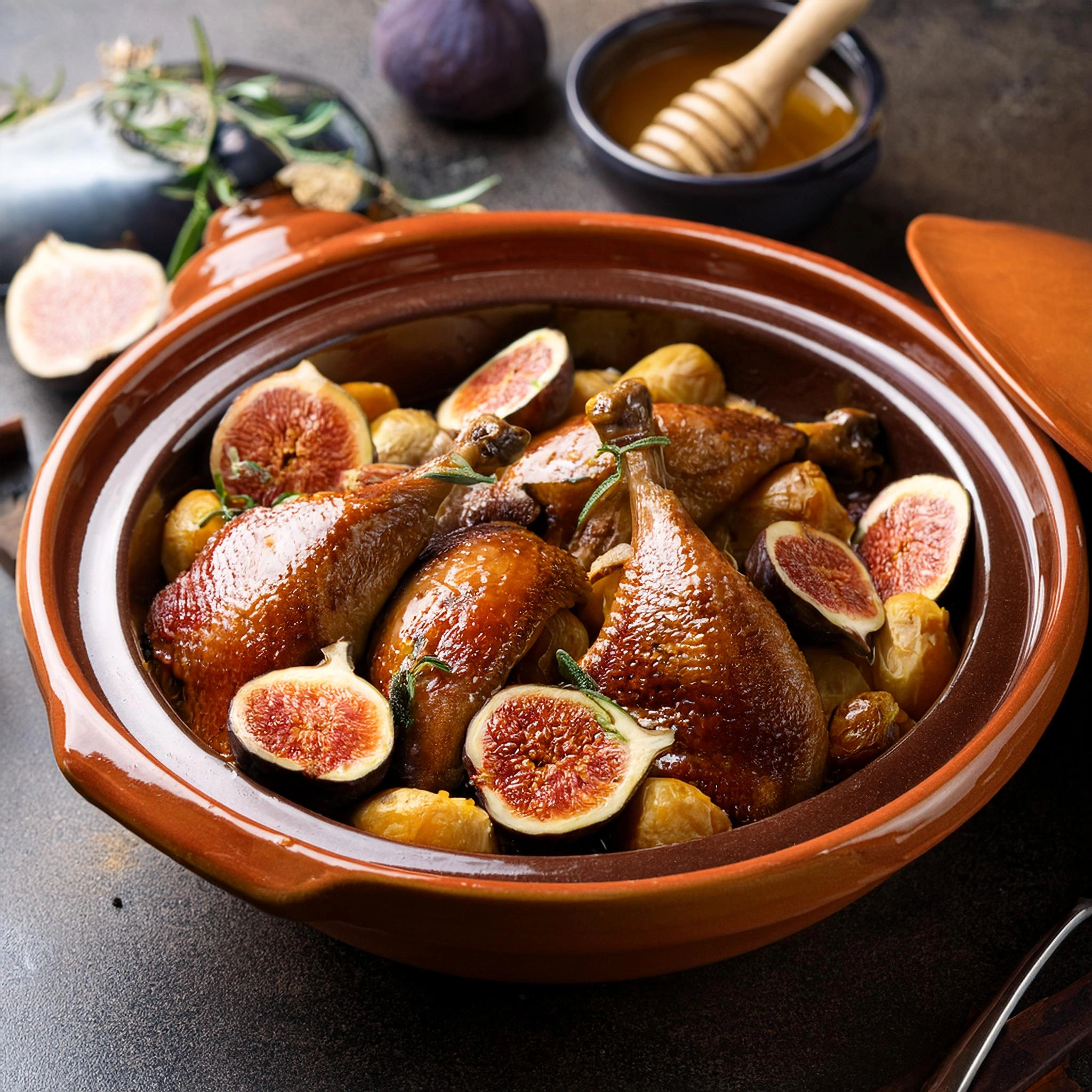 Traditional Moroccan duck tagine with figs and honey served in a clay dish.