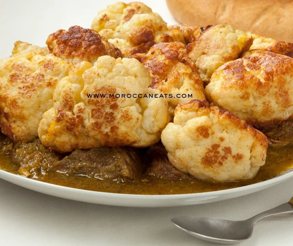 Lamb Tagine with Fried Cauliflower – Shockingly Good 2 Tender Moroccan lamb tagine topped with golden-fried cauliflower served in a traditional tagine pot with rustic decor.