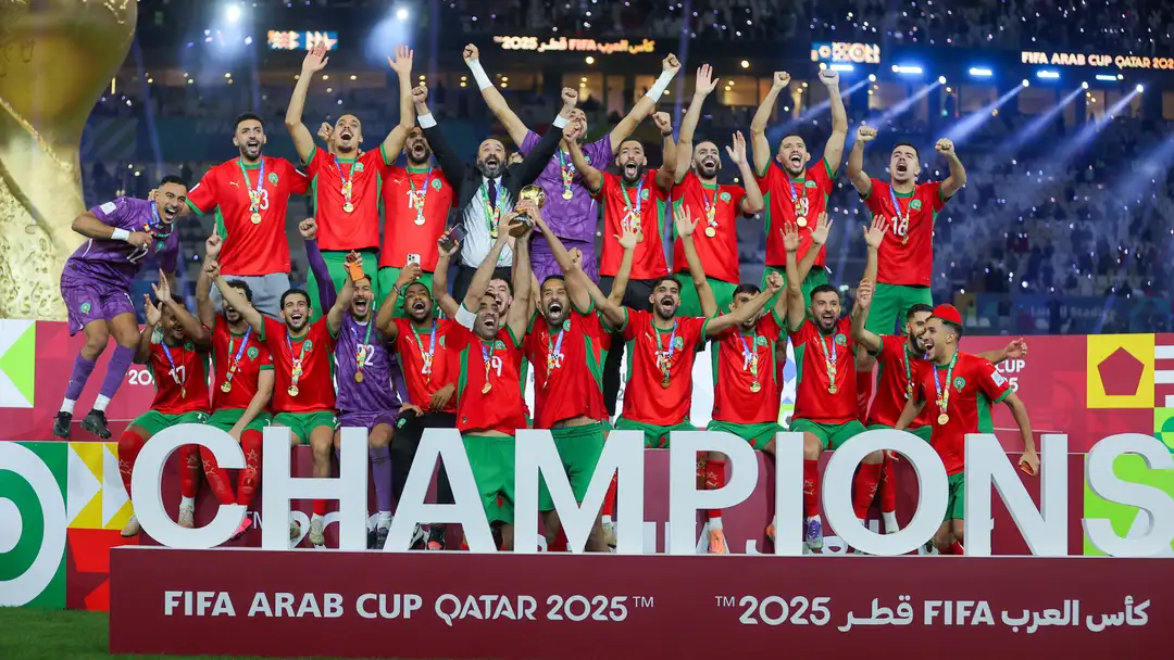 Morocco national team players celebrating their 3-2 victory over Jordan to win the FIFA Arab Cup 2025 in Qatar.